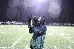 Junior Benjamin Cahoon operates a wireless camera at a football game