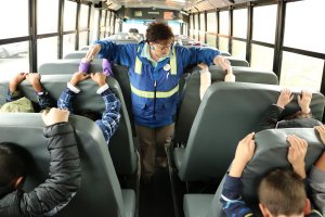 Bus driver Helen Peterson leads students through an earthquake safety drill