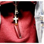 red jacket person close up photo with cross necklace