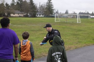 Officer teaching disc golf to students