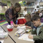 Kindergarten teacher helping students