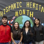 Students pose in front of a Hispanic Heritage Month display at Prairie High School