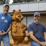 Patrick and Mike Bryson pose with their Buddy the Beaver wood carving