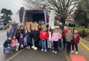 Students pose outside a van loaded with donated food