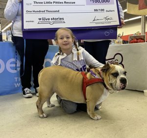 A fourth grade girl poses with her pet bulldog, Biggie